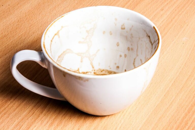 A white coffee cup with a clean exterior but stained and dirty interior, illustrating the biblical warning against appearing clean outwardly while harboring sin inwardly.